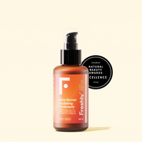 O frasco âmbar com bomba preta rotulado Freshly Creme Anticelulite e Redutor 100ml fica diante de um distintivo preto circular do Natural Beauty Awards Excellence 2024. Ideal para gordura localizada, sobre um fundo claro.