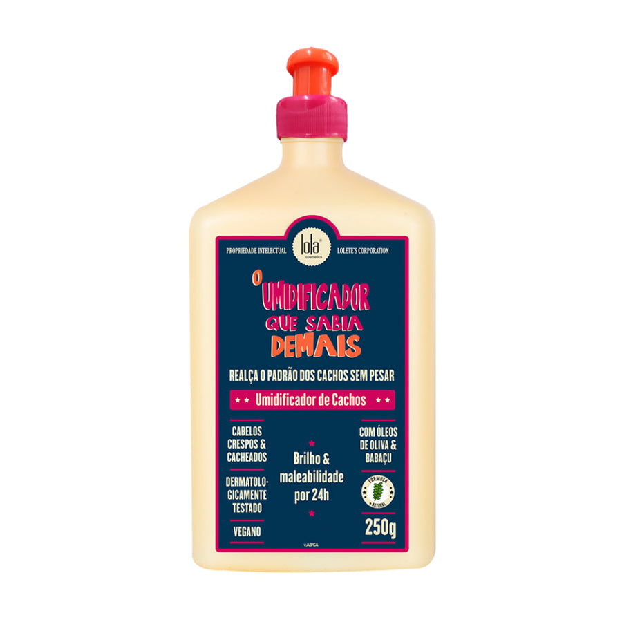 Frasco bege claro de 250g do Lola Cosmetics Umidificador Que Sabia Demais. O produto, com tampa rosa-pink e laranja, promete realçar cachos sem pesar, com óleos de oliva e babaçu, e é vegano.