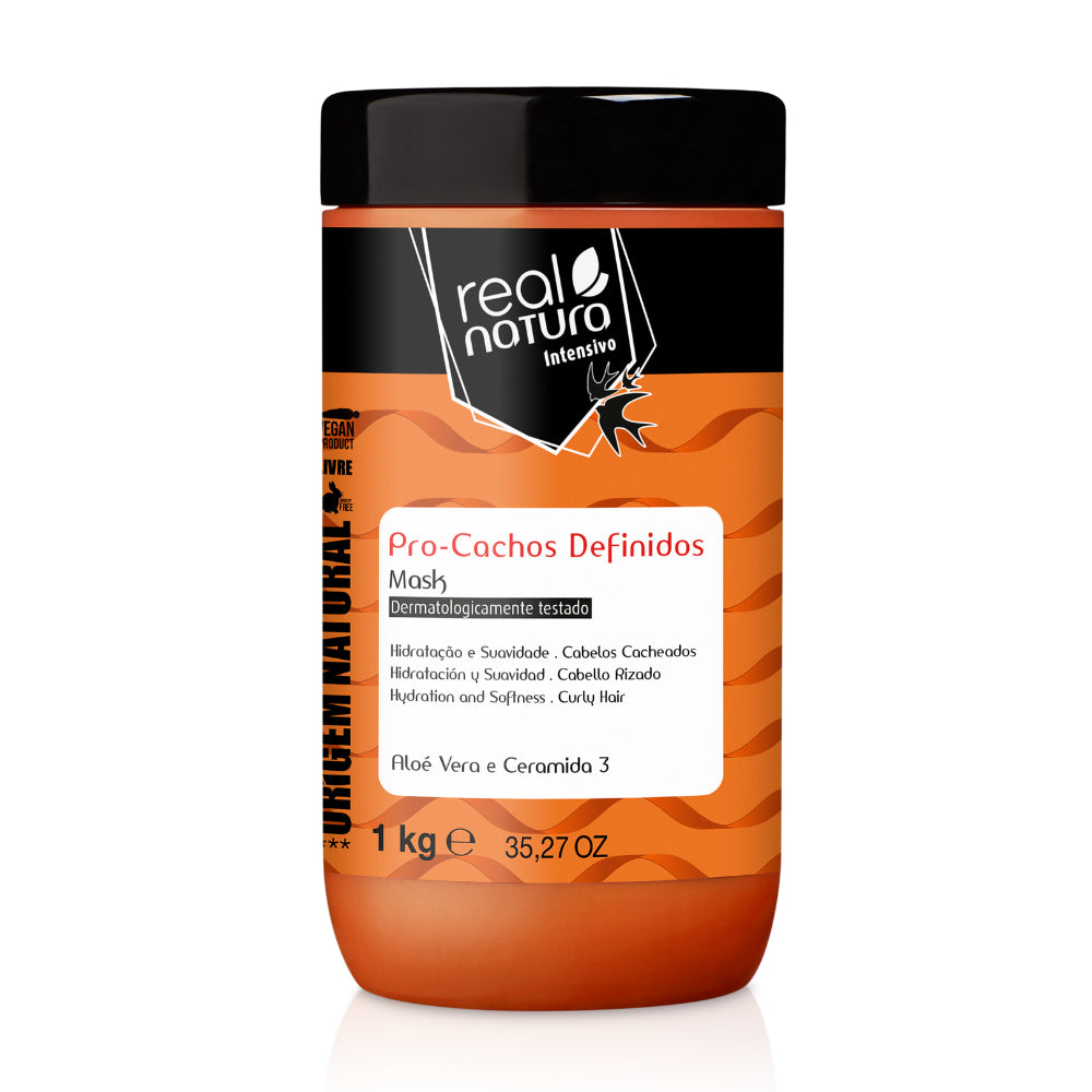 Máscara Real Natura Pro-Cachos Definidos 1kg, pote laranja e tampa preta. Com Aloe Vera e Ceramida 3, promove hidratação e suavidade para cabelos cacheados.